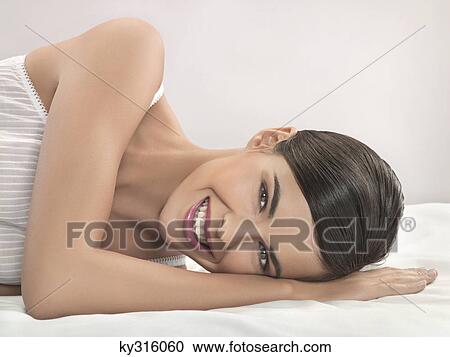 Stock Image - Young woman lying on side. Fotosearch