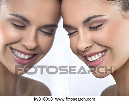 Young woman smiling and her reflection in mirror View Large Photo Image Stock Photo - Young woman smiling and her reflection in mirror. Fotosearch