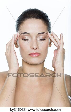 Stock Image - Young woman with fingers on temples. Fotosearch