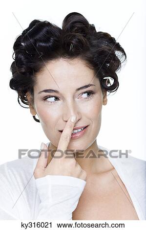 Young woman with hair clips, touching her nose View Large Photo Image Stock Image - Young woman with hair clips, touching her nose. Fotosearch