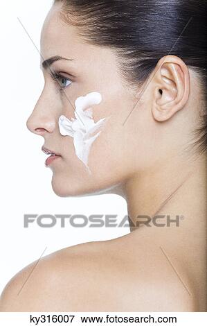 Stock Photo - Young woman with moisturizer on her cheek. Fotosearch