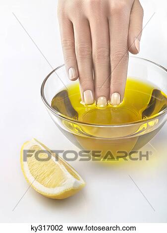 Close-up of woman's hand in bowl of olive oil View Large Photo Image Stock Image - Close-up of woman's hand in bowl of olive oil. Fotosearch