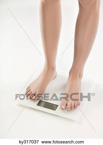 Woman on bathroom scale View Large Photo Image Stock Photo - Woman on bathroom scale. Fotosearch