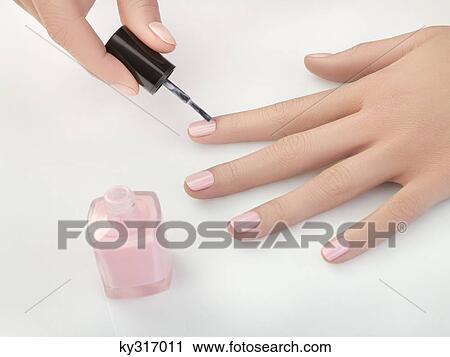Stock Image - Woman painting fingernails, close-up. Fotosearch