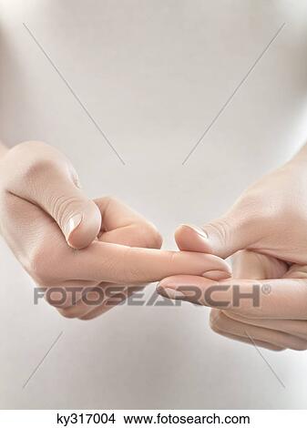 Picture - Woman pinching finger, close-up. Fotosearch