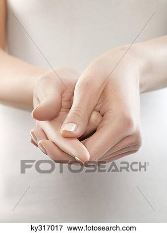 Stock Photo - Woman pinching finger, close-up. Fotosearch