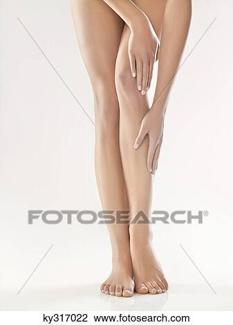 Stock Image - Woman touching her legs. Fotosearch
