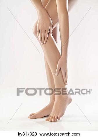 Woman touching her legs View Large Photo Image Stock Photo - Woman touching her legs. Fotosearch