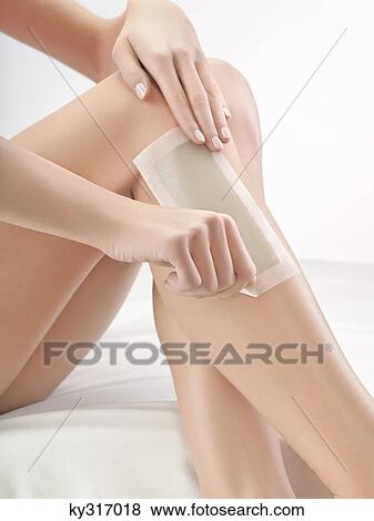 Stock Photo - Woman waxing her leg. Fotosearch