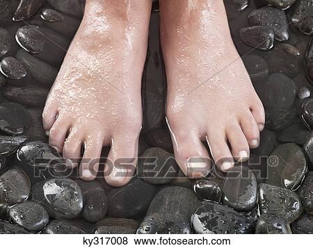 Woman's feet on pebbles View Large Photo Image Stock Photo - Woman's feet on pebbles. Fotosearch