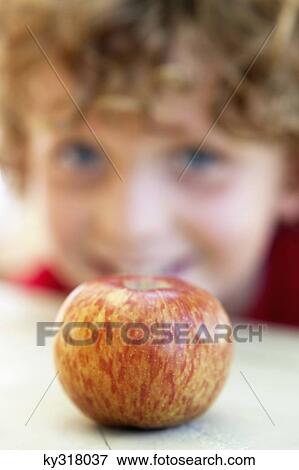 Close-up of an apple with a boy in the background View Large Photo Image Stock Photo - Close-up of an apple with a boy in the background. Fotosearch