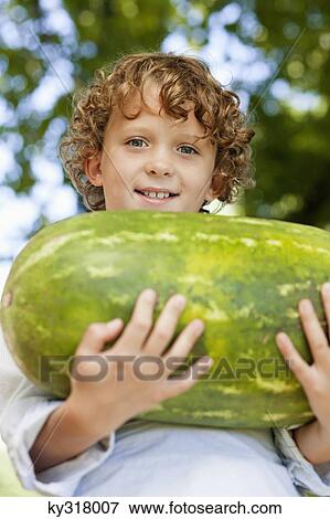 Close-up of smiling boy holding watermelon View Large Photo Image Stock Photo - Close-up of smiling boy holding watermelon. Fotosearch