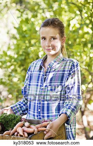 Girl holding a crate of vegetables View Large Photo Image Stock Image - Girl holding a crate of vegetables. Fotosearch