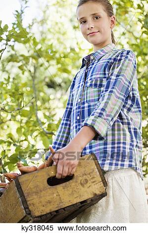 Stock Photography - Girl holding a crate of vegetables. Fotosearch