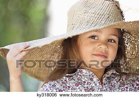 Stock Photograph - Portrait of a cute girl wearing a sunhat and smiling. Fotosearch