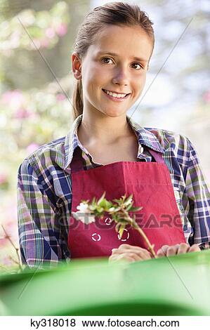 Stock Photo - Portrait of a girl gardening and smiling. Fotosearch
