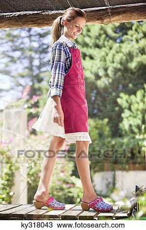 Smiling girl walking on a pier View Large Photo Image Stock Image - Smiling girl walking on a pier. Fotosearch