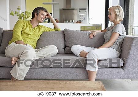 Couple having conversation in living room View Large Photo Image Stock Photo - Couple having conversation in living room. Fotosearch