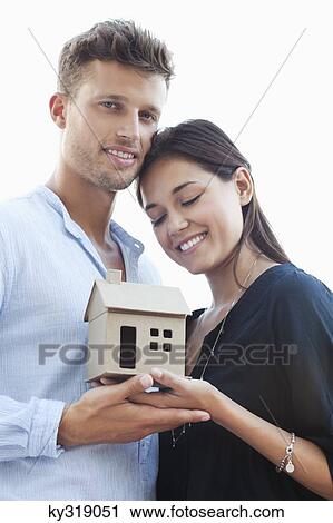 Cute young couple holding small model house View Large Photo Image Stock Image - Cute young couple holding small model house. Fotosearch