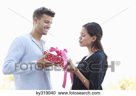Stock Image - Man giving a present to his girlfriend. Fotosearch