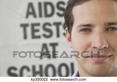 Close-up of a man in front of AIDS awareness poster View Large Photo Image Stock Image - Close-up of a man in front of AIDS awareness poster. Fotosearch