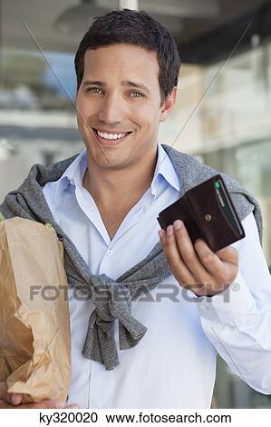 Portrait of a man showing empty wallet with paper bag full of vegetables View Large Photo Image Stock Image - Portrait of a man showing empty wallet with paper bag full of vegetables. Fotosearch