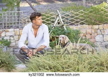 Contemplative man with a dog in garden View Large Photo Image Stock Image - Contemplative man with a dog in garden. Fotosearch