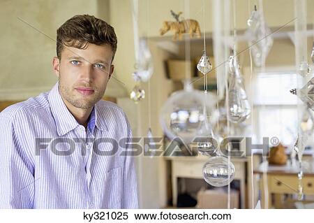 Portrait of a man standing by the wind chime at house View Large Photo Image Stock Photography - Portrait of a man standing by the wind chime at house. Fotosearch