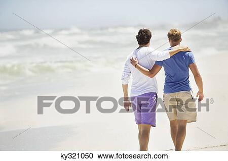 Rear view of two men walking with their arms around each other View Large Photo Image Stock Image - Rear view of two men walking with their arms around each other. Fotosearch