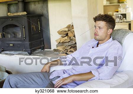 Stock Photo - Side profile of a man sitting in an armchair. Fotosearch