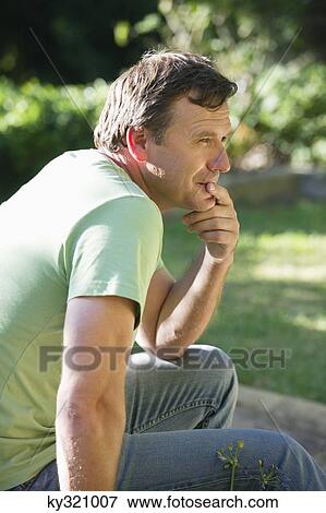 Stock Photo - Side profile of a mature man thinking with hand on chin. Fotosearch