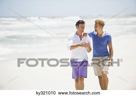 Two men walking on the beach View Large Photo Image Stock Image - Two men walking on the beach. Fotosearch