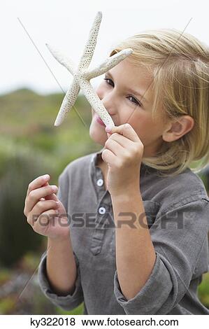 Close-up of a girl smelling a star shaped toy View Large Photo Image Stock Photo - Close-up of a girl smelling a star shaped toy. Fotosearch