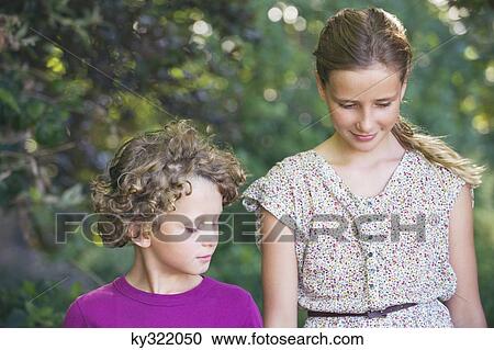 Cute little siblings walking together in a garden View Large Photo Image Stock Image - Cute little siblings walking together in a garden. Fotosearch