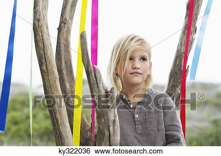 Girl standing near a tree decorated with ribbon View Large Photo Image Stock Photograph - Girl standing near a tree decorated with ribbon. Fotosearch