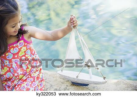 Little girl sitting by the swimming pool and looking at model of boat View Large Photo Image Stock Image - Little girl sitting by the swimming pool and looking at model of boat. Fotosearch