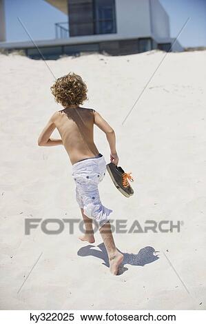 Rear view of a boy running on the beach View Large Photo Image Stock Photography - Rear view of a boy running on the beach. Fotosearch