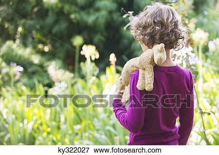 Rear view of a little boy walking in a garden View Large Photo Image Stock Photo - Rear view of a little boy walking in a garden. Fotosearch