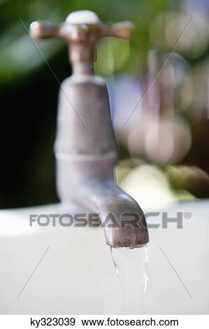 Close-up of running water from a brass faucet View Large Photo Image Stock Photo - Close-up of running water from a brass faucet. Fotosearch