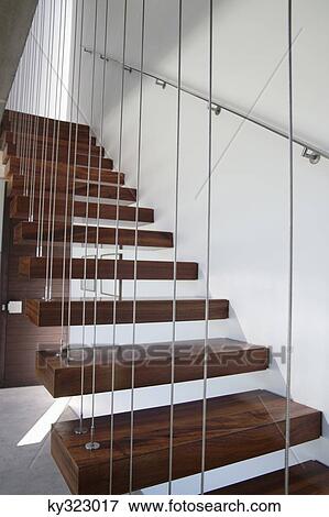 Stock Photo - Wooden staircase with white walls and metal railing. Fotosearch
