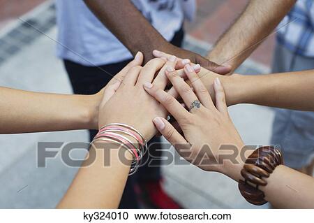 Close-up of human hands stacked upon one another View Large Photo Image Stock Image - Close-up of human hands stacked upon one another. Fotosearch
