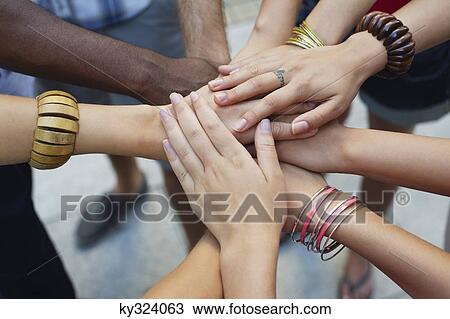 Stock Image - Close-up of human hands stacked upon one another. Fotosearch