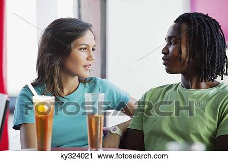 Couple sitting together in a restaurant View Large Photo Image Stock Image - Couple sitting together in a restaurant. Fotosearch