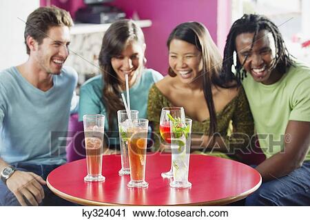 Friends sitting in a restaurant with focus on beverage View Large Photo Image Stock Image - Friends sitting in a restaurant with focus on beverage. Fotosearch