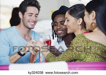 Friends toasting drinks in a restaurant View Large Photo Image Stock Photo - Friends toasting drinks in a restaurant. Fotosearch