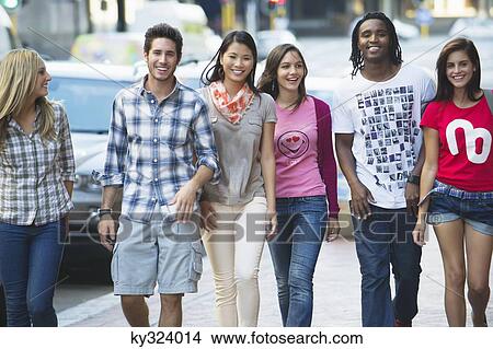 Friends walking on the sidewalk against cars View Large Photo Image Picture - Friends walking on the sidewalk against cars. Fotosearch