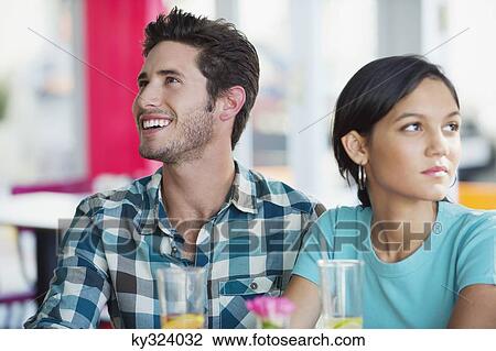 Man smiling with his girlfriend looking sad in a restaurant View Large Photo Image Stock Image - Man smiling with his girlfriend looking sad in a restaurant. Fotosearch