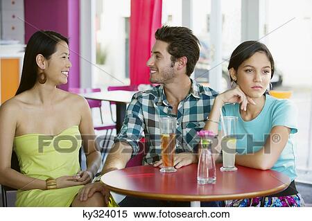 Man talking to a woman while their friend looking away View Large Photo Image Stock Photography - Man talking to a woman while their friend looking away. Fotosearch