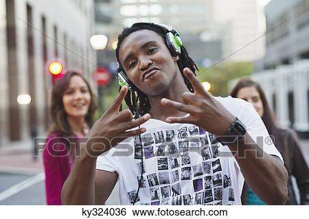 Portrait of an African American listening to music with friends in the background View Large Photo Image Stock Photograph - Portrait of an African American listening to music with friends in the background. Fotosearch