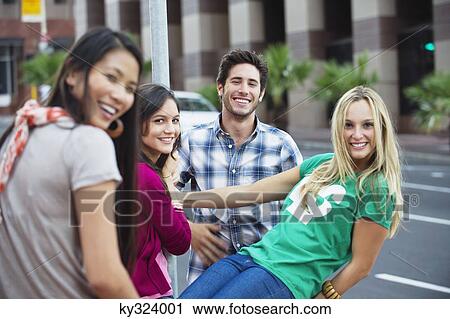 Portrait of friends standing together and smiling on the road View Large Photo Image Stock Image - Portrait of friends standing together and smiling on the road. Fotosearch